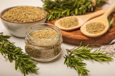 Kasede kurutulmuş biberiye ve beyaz ahşap arka planda taze biberiye dalları. Et ve balık pişirmek için baharatlı baharatlar. Yemek tarifi. Taze biberiye. Metin için yer, kopyalamak için yer.