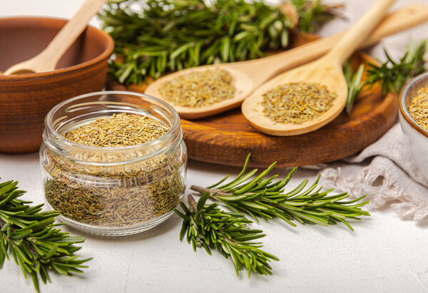 Сушеный розмарин в миске и ветви свежего розмарина на винтажном белом деревянном фоне. Пряные специи для приготовления мяса и рыбы. Рецепт. Свежая розмариновая трава. Место для текста, место для копирования.