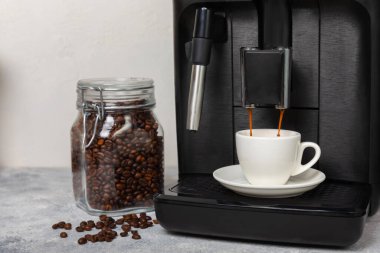 Modern espresso kahve makinesi. Mutfağın içinde bir fincan var. Taze kahve yapmak için bir makine. Yakın çekim. Kahve evi konsepti. Mesaj için yer. Kopyalanacak yer.