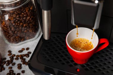 Modern espresso kahve makinesi. Mutfağın içinde bir fincan var. Taze kahve yapmak için bir makine. Yakın çekim. Kahve evi konsepti. Mesaj için yer. Kopyalanacak yer.