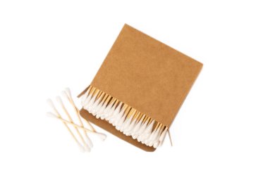 Beyaz arka planda, eko kraft ambalajlı pamuk tomurcukları izole edilmiş. Beyaz arka planda pamuklu çubuk. Burun ve kulaklarda hijyen çubukları. Bambu pamuk tomurcukları. Çevre dostu.