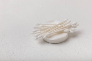 Dokulu çimento arka planında pamuk tomurcukları. Beyaz arka planda pamuklu çubuk. Burun ve kulaklarda hijyen çubukları. Plastik pamuklu bez. Pamuk yünü. Metin için boşluk. Kopyalamak için boşluk.