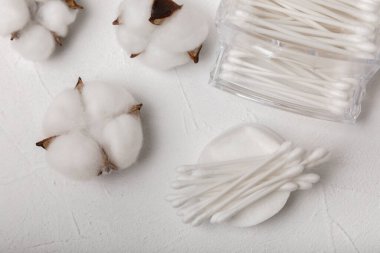 Dokulu çimento arka planında pamuk tomurcukları. Beyaz arka planda pamuklu çubuk. Burun ve kulaklarda hijyen çubukları. Plastik pamuklu bez. Pamuk yünü. Metin için boşluk. Kopyalamak için boşluk.