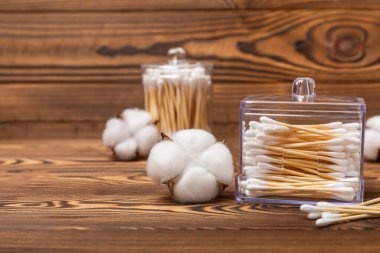 Dokulu kahverengi arka planda pamuk tomurcukları. Beyaz arka planda pamuklu çubuk. Burun ve kulaklarda hijyen çubukları. Bambu pamuk tomurcukları. Eko-dost. Mesaj için yer. Kopya için yer..