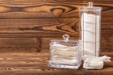 Dokulu kahverengi arka planda pamuk tomurcukları. Beyaz arka planda pamuklu çubuk. Burun ve kulaklarda hijyen çubukları. Metin için boşluk. Kopyalamak için boşluk.