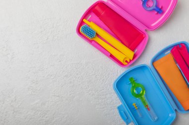Oral care.Travel set with a toothbrush, toothbrush and toothpaste in a case.Composition on a textural bright background. Dentist concept. Flat lay. copy space.Place for text
