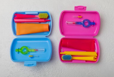 Oral care.Travel set with a toothbrush, toothbrush and toothpaste in a case.Composition on a textural bright background. Dentist concept. Flat lay. copy space.Place for text