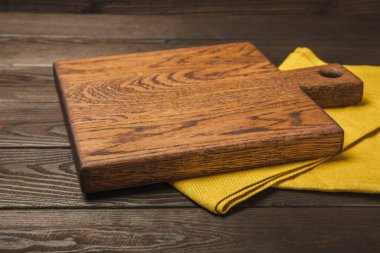 Mutfak havlusunun üzerinde tahta kesme sehpası var. Yemek tarifi. Mutfak eşyaları. Boş, modern tahta kesme tahtası. Menü. - Model. Mesaj için yer. Kopyalanacak yer.