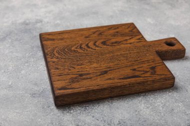 Gri mutfak masa dokusu arka planında kesim tahtası. Yemek tarifi. Mutfak eşyaları. Boş, modern tahta kesme tahtası. - Model. Mesaj için yer. Kopyalanacak yer.