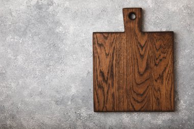 Gri mutfak masa dokusu arka planında kesim tahtası. Yemek tarifi. Mutfak eşyaları. Boş, modern tahta kesme tahtası. - Model. Mesaj için yer. Kopyalanacak yer.