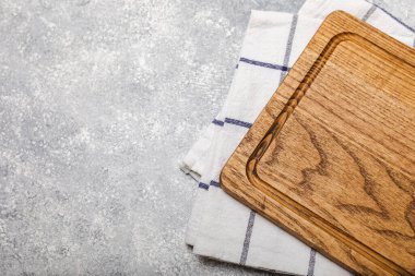 Mutfak havlusunun üzerinden tahta kesmek mutfak masası dokusu arka planında. Yemek tarifi. Mutfak eşyaları. Boş, modern tahta kesme tahtası. Menü. - Model. Mesaj için yer. Kopyalanacak yer.