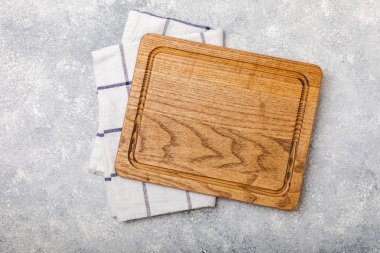 Mutfak havlusunun üzerinden tahta kesmek mutfak masası dokusu arka planında. Yemek tarifi. Mutfak eşyaları. Boş, modern tahta kesme tahtası. Menü. - Model. Mesaj için yer. Kopyalanacak yer.