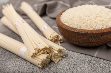 Siyah mermer arka planda pirinç eriştesi. Çiğ funselli erişte ve pilav. Tayland usulü kurutulmuş erişte. Mesaj için yer. Kopyalanacak yer. Yakın plan..