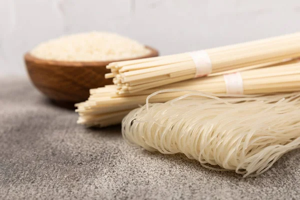 stock image Rice noodles on a black marble background. Raw funchose noodles and rice groats. Thai dried rice noodles. Place for text. Place to copy. Close-up.