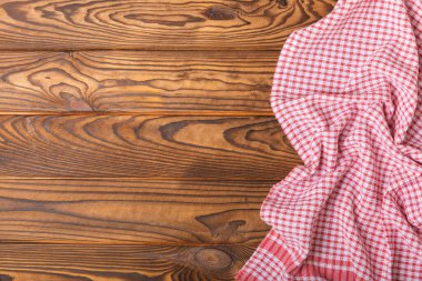 Kareli mutfak pamuk havluları kahverengi bir doku masasının üzerine katlanmış. Mutfak eşyaları. Mutfak havlusu veya tekstil peçetesi. Uzayı metin için kopyala. Mesaj için yer. Masa örtüsü.