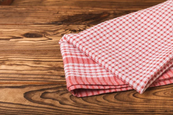 stock image Checkered kitchen cotton towels folded on a brown texture table. Kitchenware. Kitchen towel or textile napkin. Copy space for text. Place for text. Tablecloth.