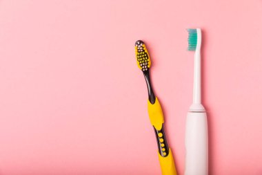 elektrikli diş fırçası, bambu ve el yapımı diş fırçaları pembe arka planda fotokopi alanı ile. Düz yatıyordu. Ağız temizliği. Ağız bakım kiti. Dişçi konsepti. Mesaj için yer. Kopyalanacak yer.