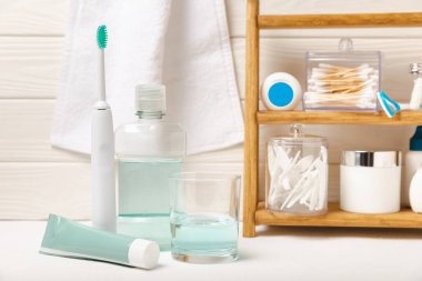 Sonik elektrikli diş fırçası, diş macunu, gargara, diş ipi ve dil temizleyicili banyo. Ağız temizliği. Diş bakımı. Diş hekimliği konsepti. Metnin yeri. Kopya için yer.