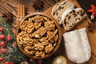 Dokuma sehpasının üzerinde yılbaşı süsleri. Geleneksel Alman Noel tatlısı parçalara ayrıldı. Fındıklı kek, tarçın, kuru üzüm, kurutulmuş meyve ve badem ezmesi. Noel için yemek pişiriyorum. Metin için yer. 