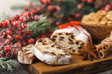 Dokuma sehpasının üzerinde yılbaşı süsleri. Geleneksel Alman Noel tatlısı parçalara ayrıldı. Fındıklı kek, tarçın, kuru üzüm, kurutulmuş meyve ve badem ezmesi. Noel için yemek pişiriyorum. Metin için yer. 