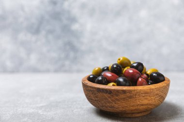 Mavi arka planda yeşil, kırmızı ve siyah zeytin seti. Farklı türde zeytin ve taze zeytin yapraklı zeytin yağları. Lezzetli. Akdeniz mutfağı. Boşluğu kopyala.