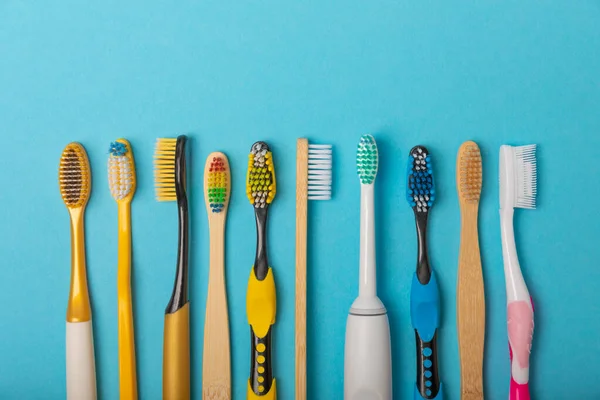 stock image Electric and manual toothbrushes on a blue background. View from above. Oral hygiene. Ordinary toothbrush, eco and electric toothbrush. Oral hygiene. Oral Care Kit. Dentist concept. Dental care. 