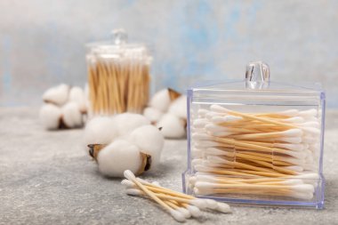 Mavi desenli arka planda beyaz pamuklu çubuklar. Pamuk tomurcukları. Bambu pamuk tomurcukları. Çevre dostu. Kulaklar için hijyenik pamuklu bez. Mesaj için yer. Kopyalanacak yer.