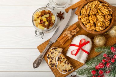 Ahşap arka planda Noel çalıntısı. Geleneksel Noel şenlikli pasta tatlısı. Noel için çalınmış. Noel meyveli pasta, beyaz tabakta puding. Geleneksel Alman Noel pastası..