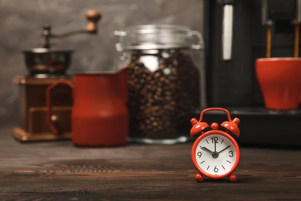 Väckarklocka Bakgrunden Kaffemaskinen Röd Väckarklocka Köksbordet Mot Bakgrund Kopp Aromatiskt — Stockfoto