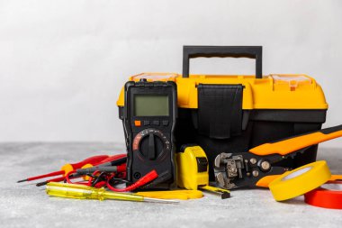 Mermer zemin üzerinde mermer arkaplan üzerinde elektrikli ekipman. Üst görünüm. Elektrik aracı seti. Çoklu metre, test cihazı, tornavida, kesiciler, koli bandı, lamba, mezura, mezura ve kablo..