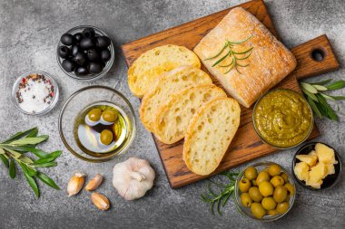 Bitki, zeytin, pesto sosu, sarımsak ve parmesan peyniri ile dilimlenmiş İtalyan ciabatta ekmeği. Taze ev yapımı İtalyan Ciabatta ekmeği. Bitki ve baharatla dilimlenmiş. Yazı için bir yer. kopyalama alanı.