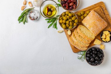 Bitki, zeytin, pesto sosu, sarımsak ve parmesan peyniri ile dilimlenmiş İtalyan ciabatta ekmeği. Taze ev yapımı İtalyan Ciabatta ekmeği. Bitki ve baharatla dilimlenmiş. Yazı için bir yer. kopyalama alanı.