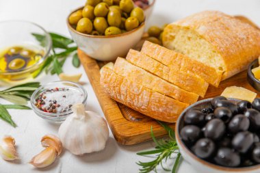 Bitki, zeytin, pesto sosu, sarımsak ve parmesan peyniri ile dilimlenmiş İtalyan ciabatta ekmeği. Taze ev yapımı İtalyan Ciabatta ekmeği. Bitki ve baharatla dilimlenmiş. Yazı için bir yer. kopyalama alanı.