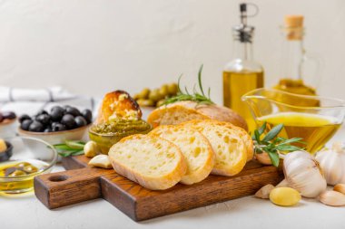 Bitki, zeytin, pesto sosu, sarımsak ve parmesan peyniri ile dilimlenmiş İtalyan ciabatta ekmeği. Taze ev yapımı İtalyan Ciabatta ekmeği. Bitki ve baharatla dilimlenmiş. Yazı için bir yer. kopyalama alanı.