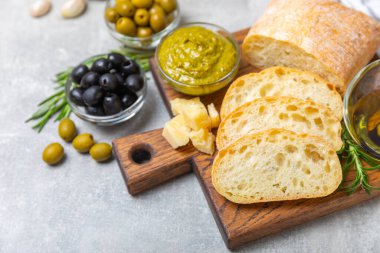 Bitki, zeytin, pesto sosu, sarımsak ve parmesan peyniri ile dilimlenmiş İtalyan ciabatta ekmeği. Taze ev yapımı İtalyan Ciabatta ekmeği. Bitki ve baharatla dilimlenmiş. Yazı için bir yer. kopyalama alanı.