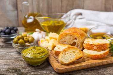 Bitkilerle, zeytinlerle, pesto sosuyla, sarımsak ve parmesanlı peynirle dilimlenmiş İtalyan ciabatta ekmeği. Taze ev yapımı İtalyan Ciabatta ekmeği. Bitki ve baharatla dilimlenmiş. Yazı için bir yer. kopyalama alanı.