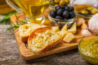 Bitkilerle, zeytinlerle, pesto sosuyla, sarımsak ve parmesanlı peynirle dilimlenmiş İtalyan ciabatta ekmeği. Taze ev yapımı İtalyan Ciabatta ekmeği. Bitki ve baharatla dilimlenmiş. Yazı için bir yer. kopyalama alanı.