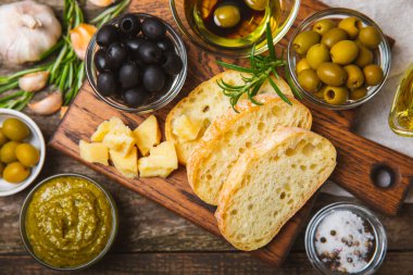 Bitkilerle, zeytinlerle, pesto sosuyla, sarımsak ve parmesanlı peynirle dilimlenmiş İtalyan ciabatta ekmeği. Taze ev yapımı İtalyan Ciabatta ekmeği. Bitki ve baharatla dilimlenmiş. Yazı için bir yer. kopyalama alanı.