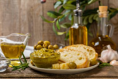 Bitkilerle, zeytinlerle, pesto sosuyla, sarımsak ve parmesanlı peynirle dilimlenmiş İtalyan ciabatta ekmeği. Taze ev yapımı İtalyan Ciabatta ekmeği. Bitki ve baharatla dilimlenmiş. Yazı için bir yer. kopyalama alanı.