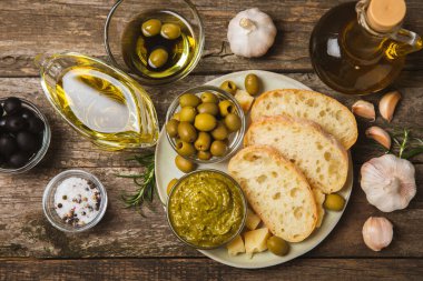 Bitkilerle, zeytinlerle, pesto sosuyla, sarımsak ve parmesanlı peynirle dilimlenmiş İtalyan ciabatta ekmeği. Taze ev yapımı İtalyan Ciabatta ekmeği. Bitki ve baharatla dilimlenmiş. Yazı için bir yer. kopyalama alanı.