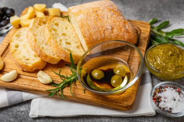 Bitki, zeytin, pesto sosu, sarımsak ve parmesan peyniri ile dilimlenmiş İtalyan ciabatta ekmeği. Taze ev yapımı İtalyan Ciabatta ekmeği. Bitki ve baharatla dilimlenmiş. Yazı için bir yer. kopyalama alanı.