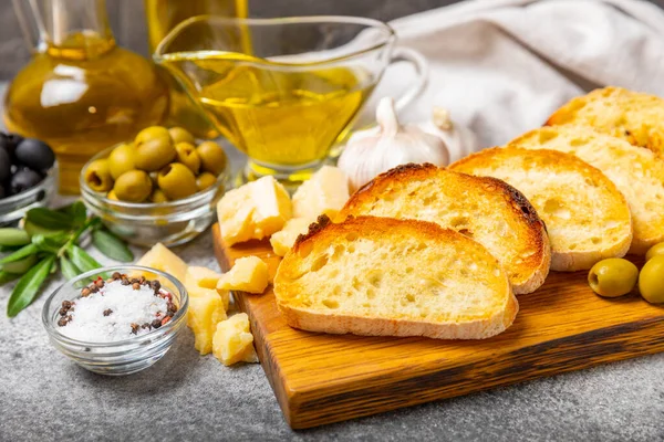 Stock image Italian ciabatta bread cut in slices with herbs, olives, pesto sauce, garlic and parmesan cheese on a concrete table. Fresh homemade Italian Ciabatta bread sliced with herbs and spices.Place for text. copyspace.