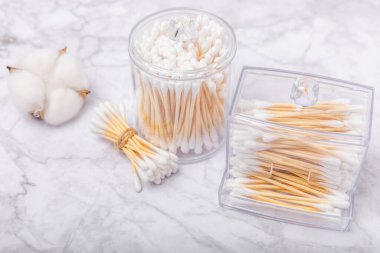 Beyaz mermer zeminde pamuk tomurcukları. Pamuklu bez. Temiz pamuk tomurcukları. Hijyen ürünleri. Kulak çubukları. Mesaj için yer. Kopyalanacak yer. Yakın plan. Düz yatıyordu.