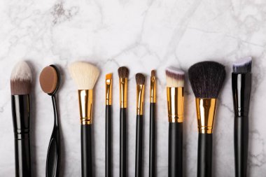 Beyaz mermer arka planda kozmetik makyaj fırçası. Profesyonel makyaj fırçaları. Göz farı, kızarıklık, temel ve dış hatlı fırçalar. Makyaj aleti. Vizeci. Metin için yer. Boşluğu kopyala