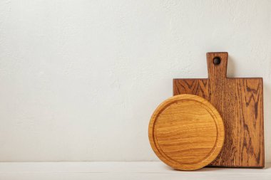 Mutfak beyaz mermer masasında boş ahşap tahta. Kesme tahtası. Tahta kesme tahtası, kopyalama alanı. Mutfak eşyaları. Yemek tarifi. Mesaj için yer. Düz yatıyordu.