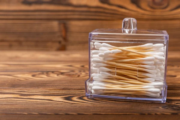 stock image White cotton swabs on a brown wood background. Cotton buds. Bamboo cotton buds. Eco-friendly. Hygienic cotton swabs for ears. Place for text. Place to copy.