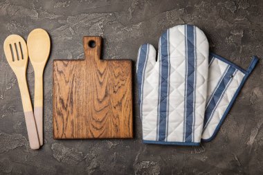 Mutfak eşyaları. Mermer desenli arka planda sıcak yemekler için fırın eldiveni ve tutacağı. Yakın plan. Mesaj için yer. Boşluğu kopyala.