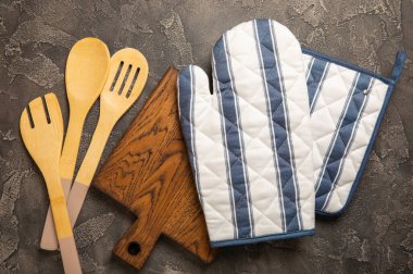 Mutfak eşyaları. Mermer desenli arka planda sıcak yemekler için fırın eldiveni ve tutacağı. Yakın plan. Mesaj için yer. Boşluğu kopyala.