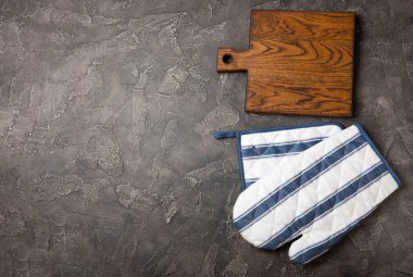 Mutfak eşyaları. Mermer desenli arka planda sıcak yemekler için fırın eldiveni ve tutacağı. Yakın plan. Mesaj için yer. Boşluğu kopyala.