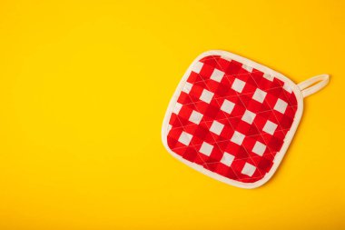 Mutfak eşyaları. Parlak sarı arka planda sıcak yemekler için fırın eldiveni ve tutacağı. Yakın plan. Mesaj için yer. Boşluğu kopyala.